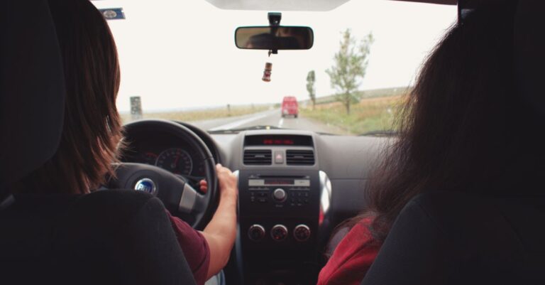 Two adults traveling by car on a scenic road near Iași, Romania.